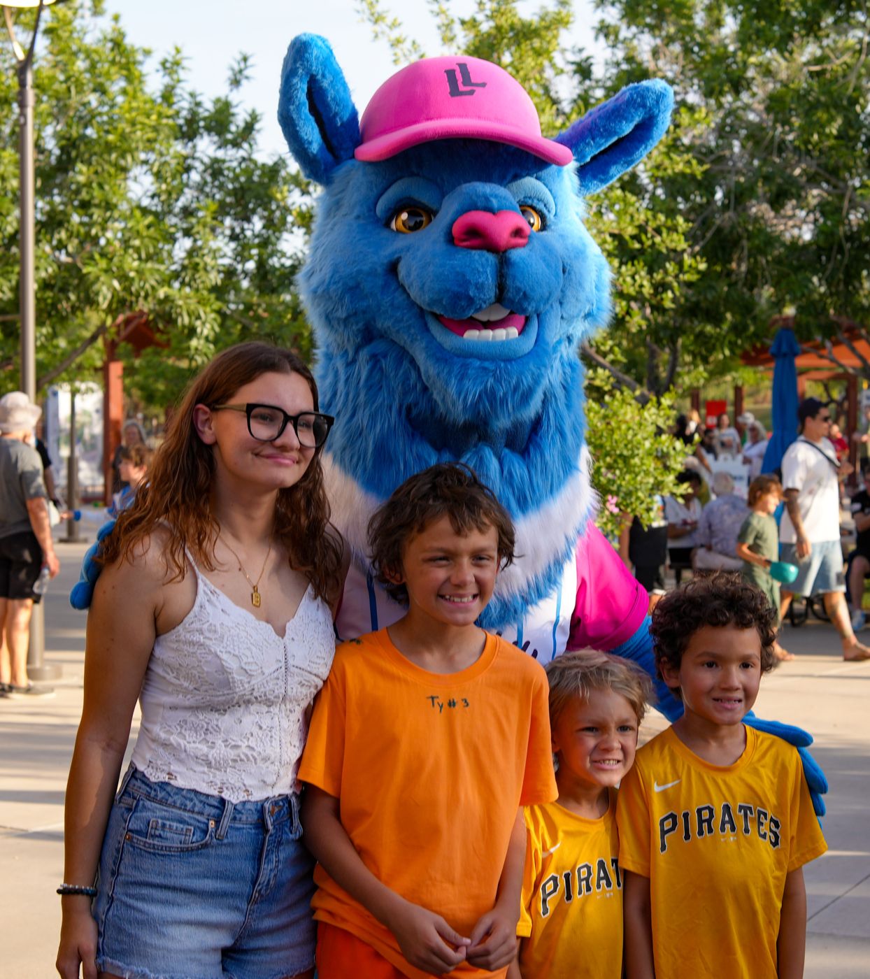 Blue llama mascot posing with kids